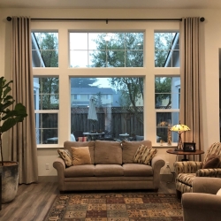 Beige Curtains on Black Curtain Rod in Living Room