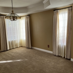 Beige Drapes with Black Curtain Rod on Dining Room Windows