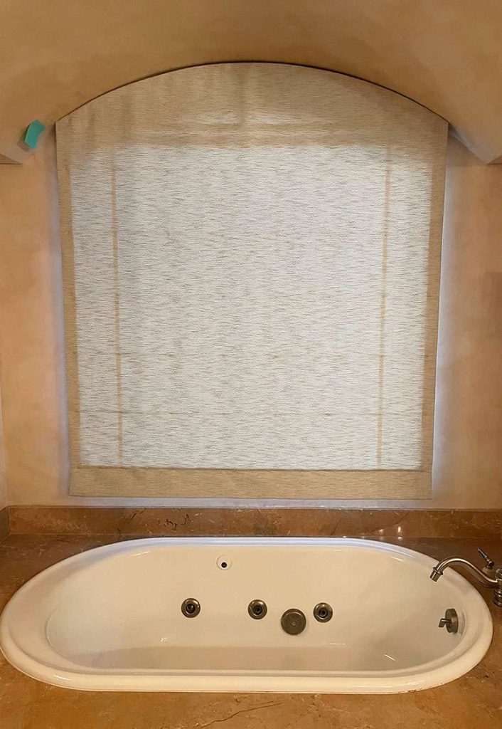motorized arched roman shade above tub