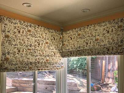 residential kitchen corner windows floral patterned plain fold roman shades